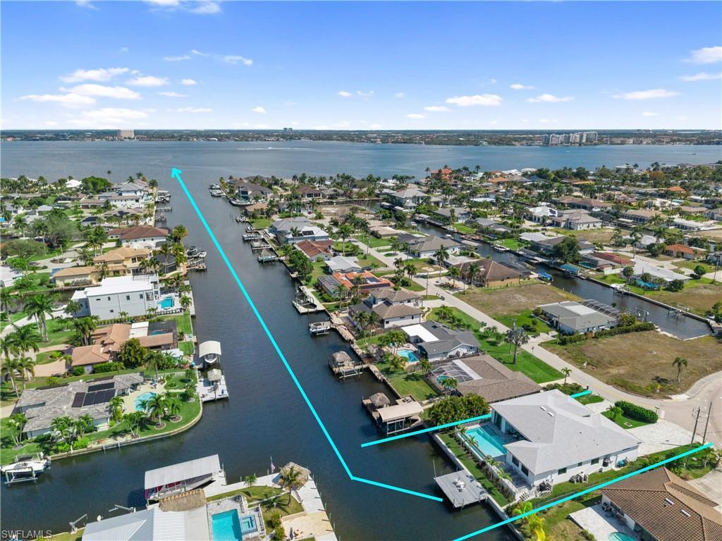 Image 1: Aerial view of residential area with a nearby body of water
