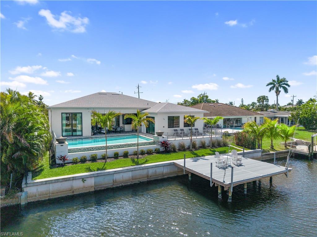 Image 2: Back of house featuring a patio area, an outdoor pool, and a water view