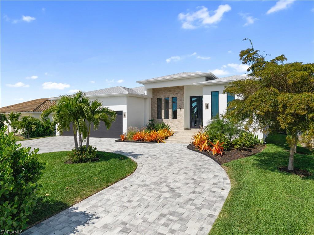 Image 3: Prairie-style home featuring curved driveway, stucco siding, and a front yard
