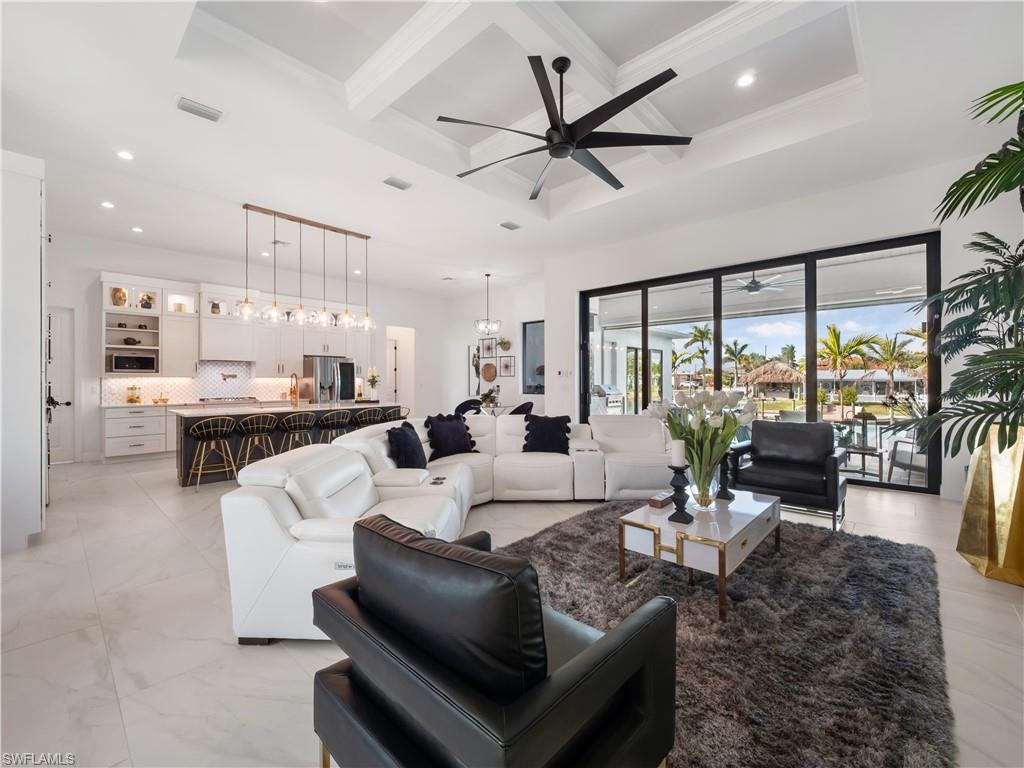 Image 4: Living area featuring coffered ceiling, a ceiling fan, and hanging lights