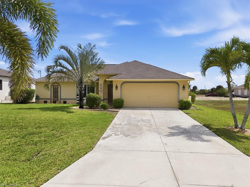 Image 2: Ranch-style home with a front yard, a garage, driveway, and stucco siding