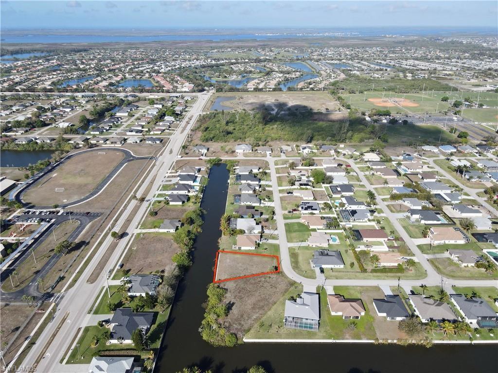 Image 2: Aerial perspective of suburban area with property boundaries highlighted and a large body of water