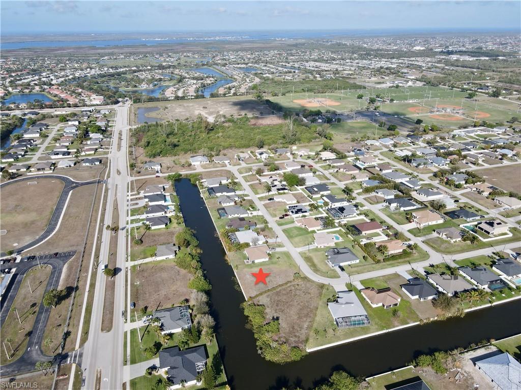 Image 3: Aerial view of property and surrounding area with a nearby body of water and nearby suburban area