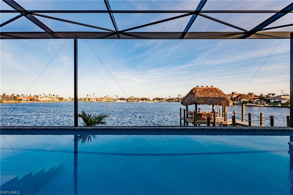 Image 2: Outdoor pool featuring a water view and a dock