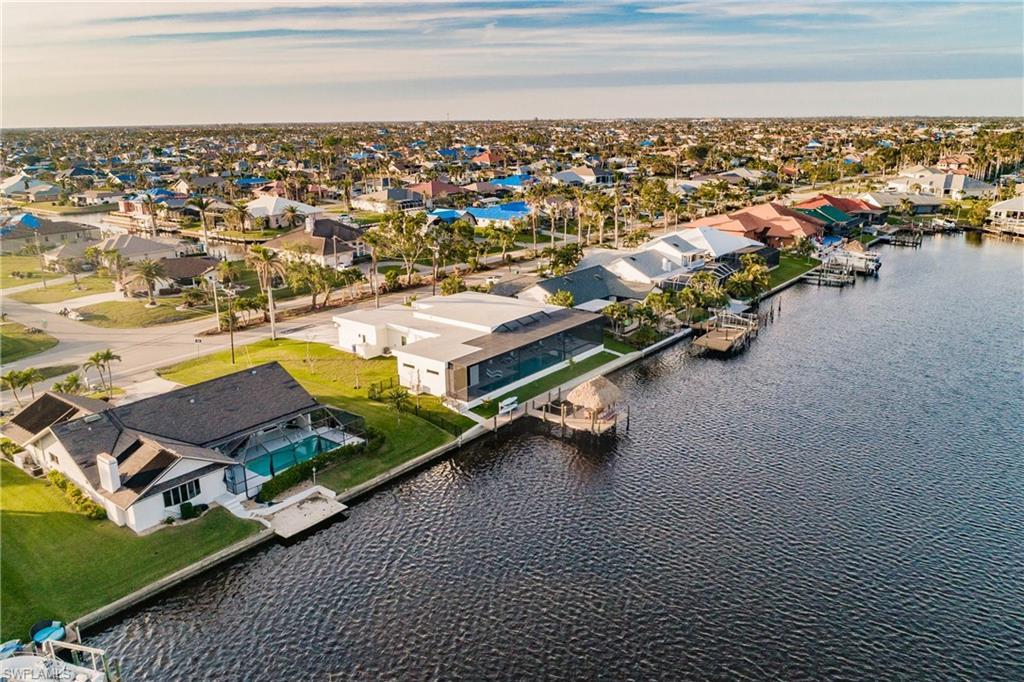 Image 3: Aerial view of residential area featuring a nearby body of water