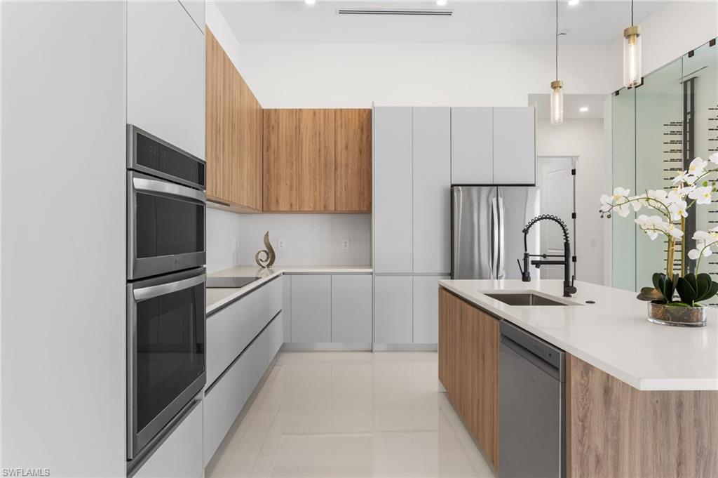 Image 1: The EXPENSIVE ISLAND offers FLEXIBLESEATING for CASUAL DINING or FORMALGATHERINGS, and a FULL QUARTZBACKSPLASH adds MODERN SOPHISTICATION