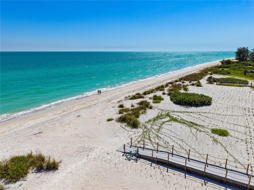 Image 3: Expansive beachfront featuring white sand, turquoise waters, and natural dunes