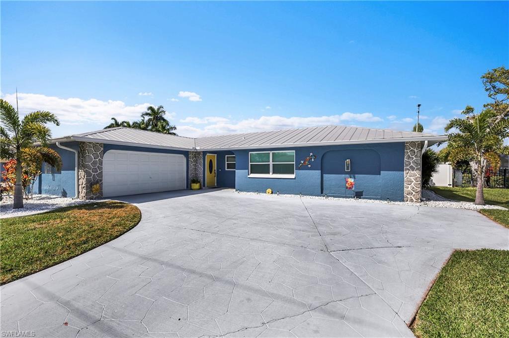 Image 3: Exterior featuring a metal roof, stone accents, and a vibrant blue facade