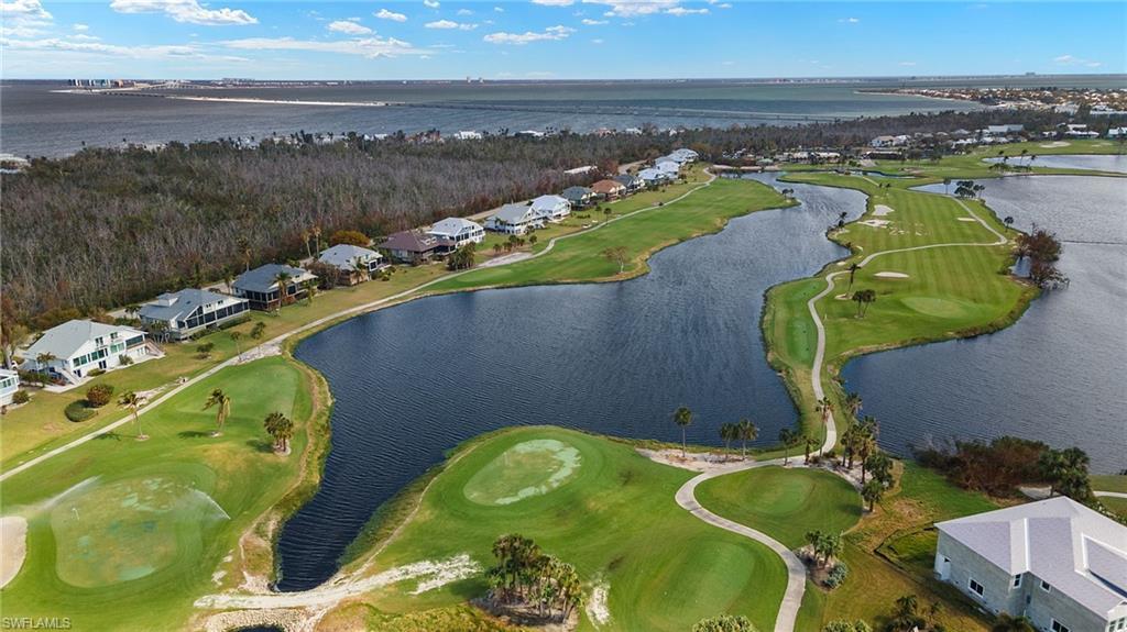 Image 2: Aerial view of property and surrounding area featuring a golf club, nearby suburban area, and a nearby body of water