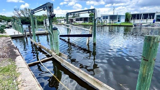 Image 3: Waterfront property featuring a private boat dock with multiple pilings and a boat lift