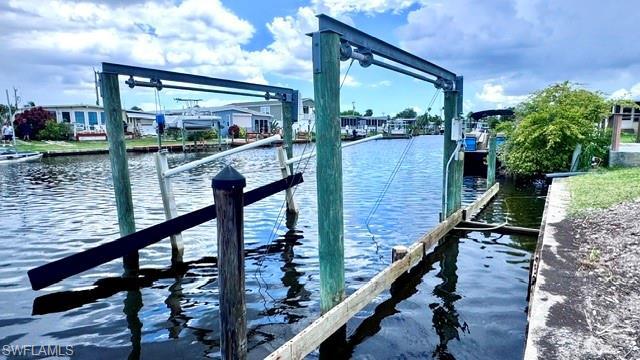 Image 4: Waterfront property featuring a boat lift with wooden pilings and a concrete seawall