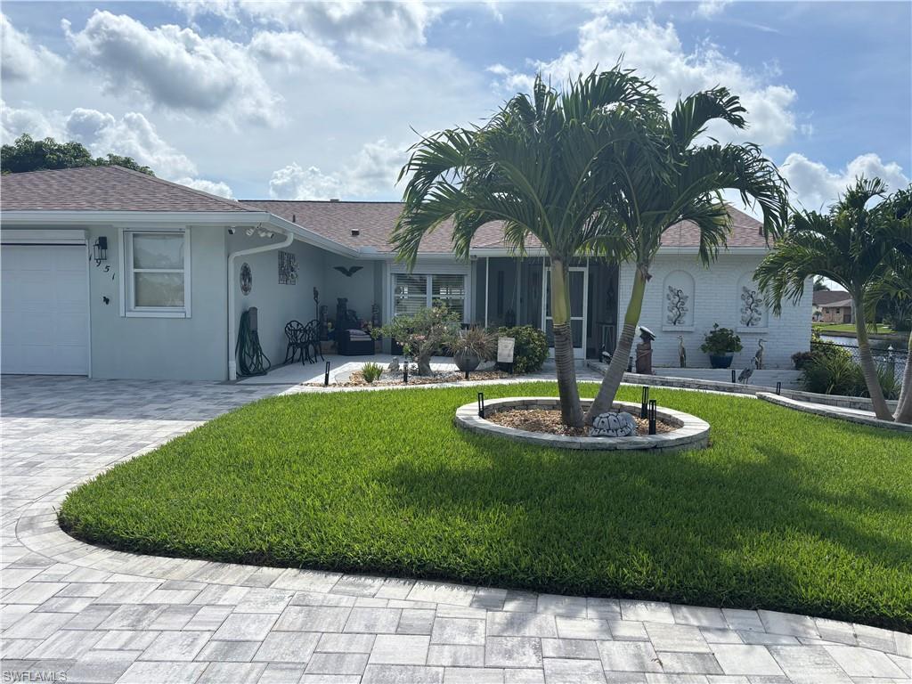 Image 4: Ranch-style house featuring a front yard, stucco siding, decorative driveway, and an attached garage