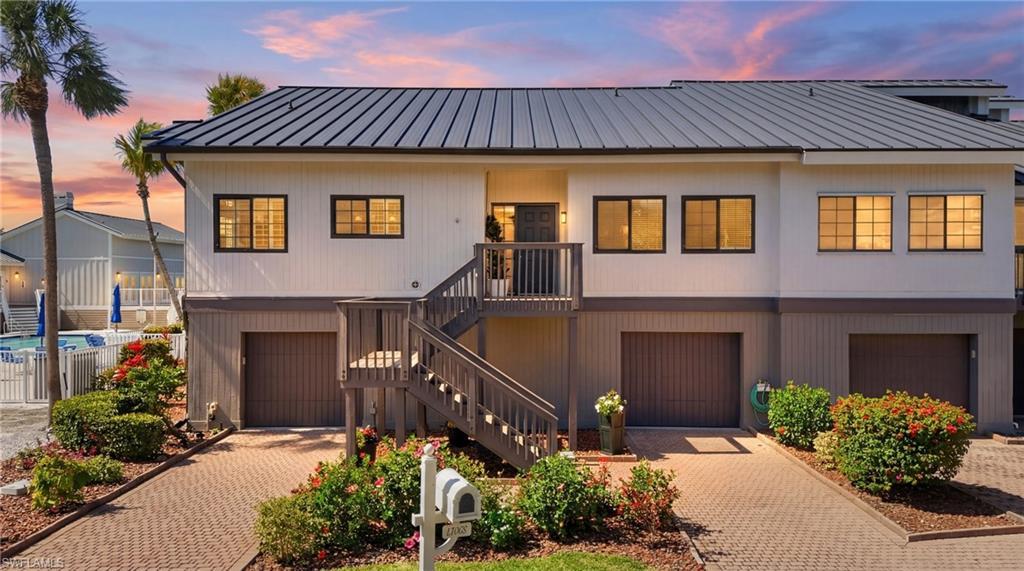 Image 1: View of front facade with decorative driveway, a garage, and a standing seam roof