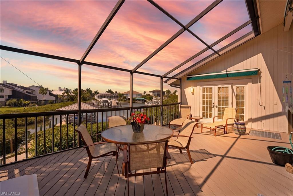 Image 2: Wooden deck with french doors, a sunroom, a lanai, a residential view, and outdoor dining area