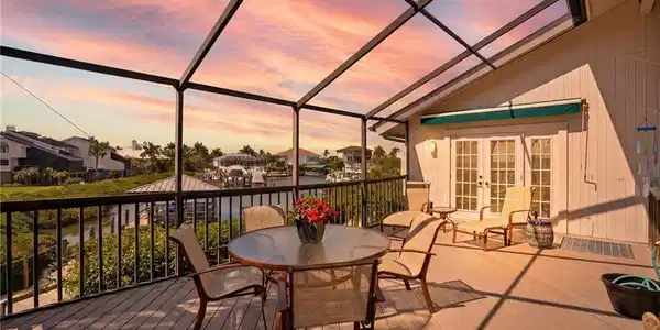 Image 2: Wooden deck with french doors, a sunroom, a lanai, a residential view, and outdoor dining area