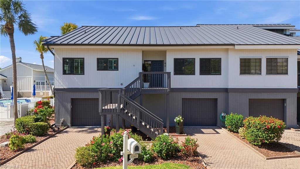 Image 4: View of front of house featuring a garage, decorative driveway, and a standing seam roof