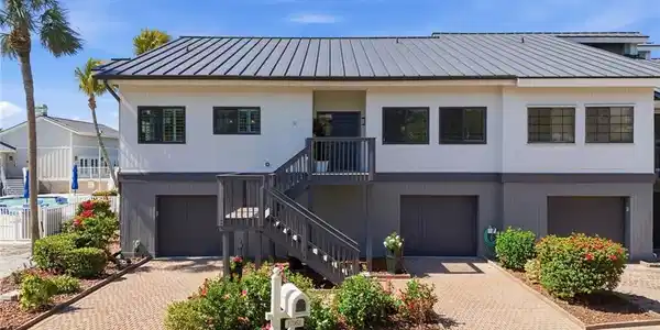 Image 4: View of front of house featuring a garage, decorative driveway, and a standing seam roof