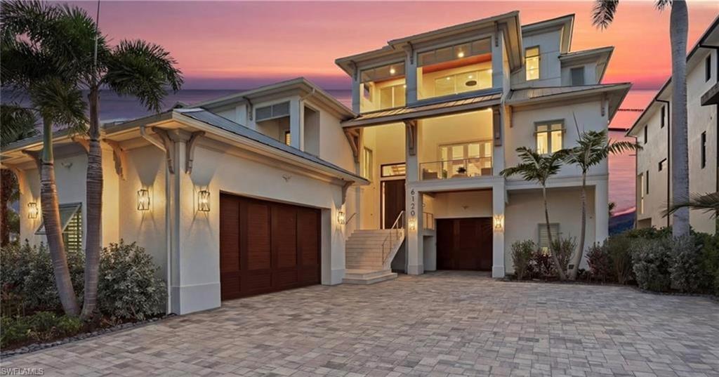 Image 1: View of front facade with stucco siding, decorative driveway, a balcony, and a standing seam roof - Virtually Edited Image