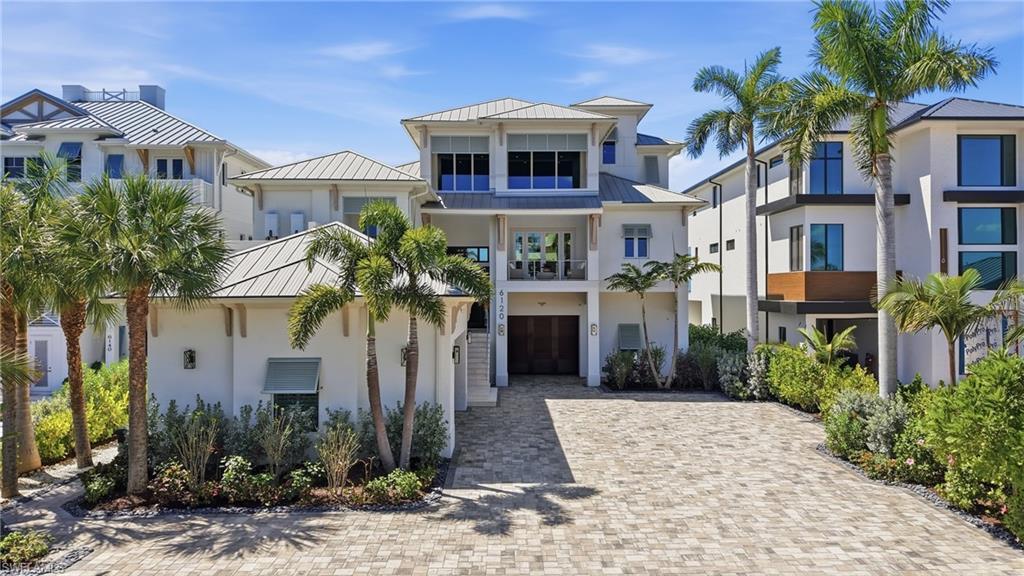 Image 3: View of front of property featuring a standing seam roof, a garage, a balcony, and driveway - Virtually Edited Image