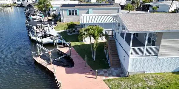 Image 3: Dock area featuring boat lift, a lawn, a residential view, and a water view