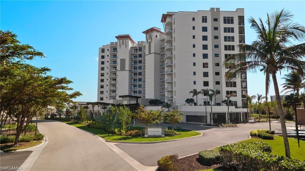 Image 2: Contemporary high-rise fa&ccedil;ade framed by tropical landscaping, palms and bright skies