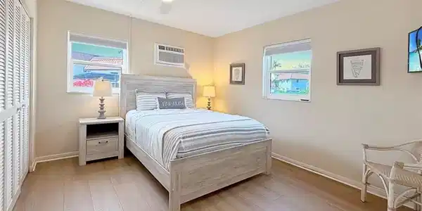 Image 2: Bedroom with ceiling fan, a closet, multiple windows, and light wood-type flooring