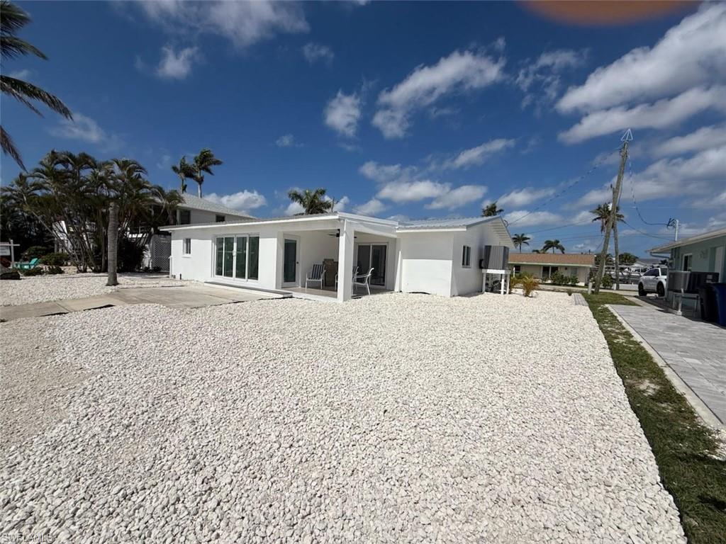 Image 4: Rear view of property with stucco siding and open patio