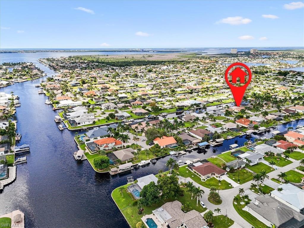 Image 1: Aerial view of residential area with a nearby body of water