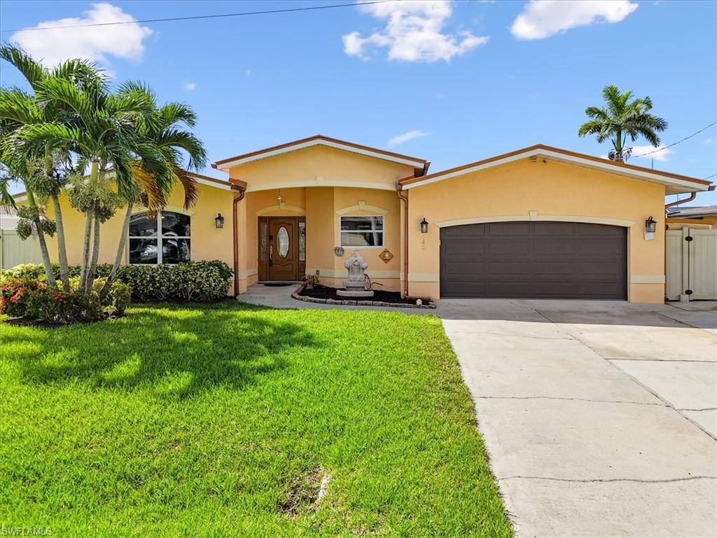 Image 3: Florida-style house featuring stucco siding, driveway, a garage, and a front lawn