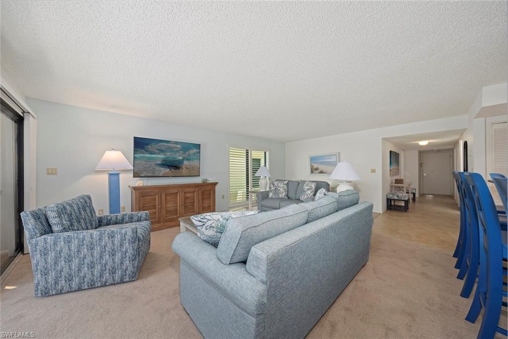 Image 4: Living room with carpet and a textured ceiling