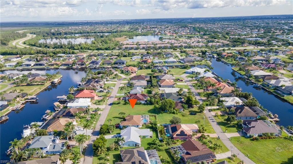 Image 4: Aerial view of property and surrounding area featuring a large body of water and nearby suburban area