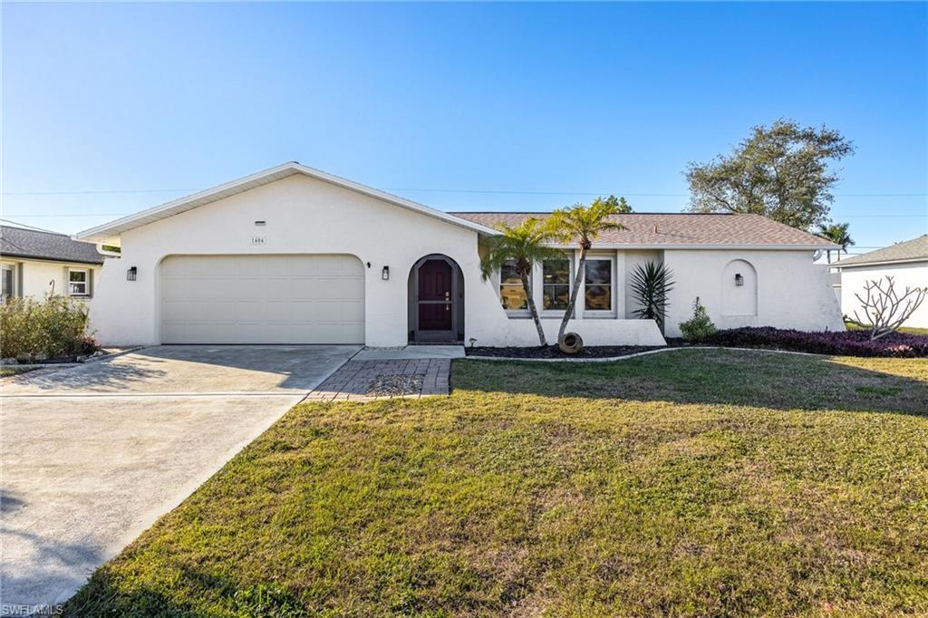 Image 1: Ranch-style home featuring a garage and a front yard