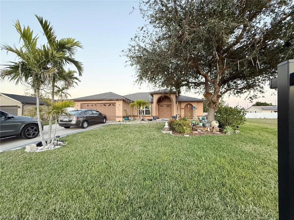 Image 3: Ranch-style home with a garage and a lawn