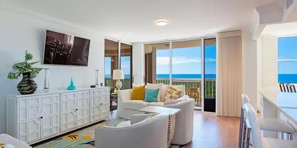 Image 3: Living area with expansive windows and wood finished floors
