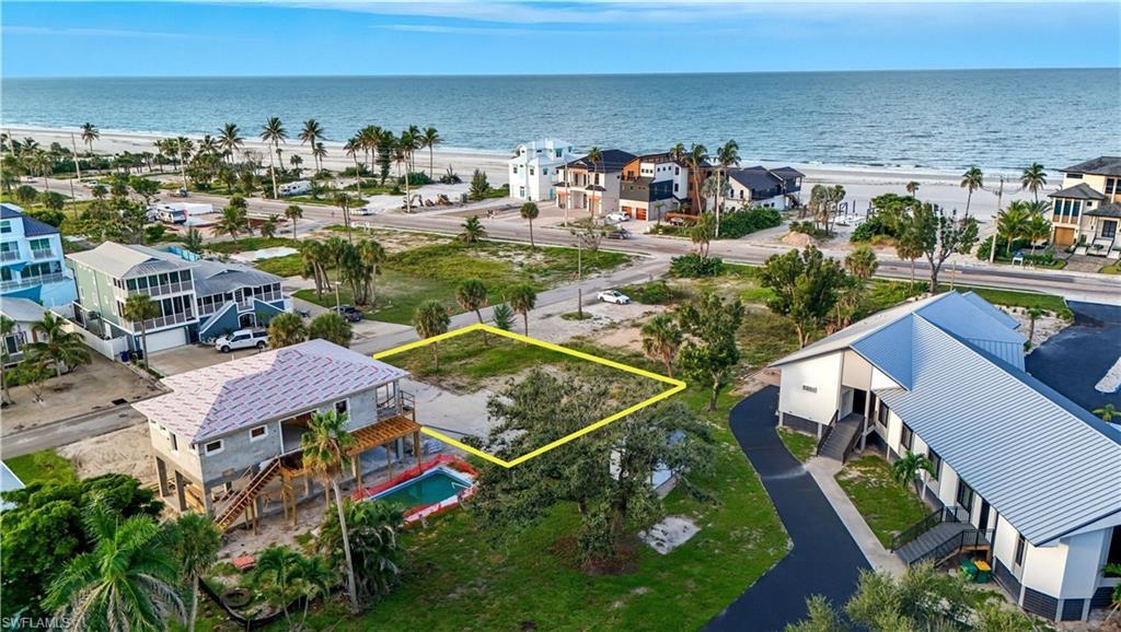 Image 2: Aerial perspective of suburban area featuring expansive beach and property boundaries highlighted - Virtually Edited Image