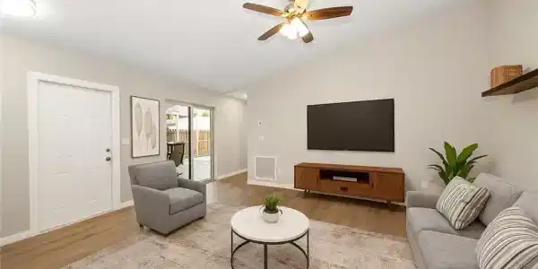 Image 2: Bedroom with multiple closets, light tile patterned floors, and a ceiling fan