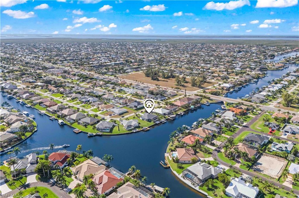 Image 4: Aerial overview of property's location with nearby suburban area and a large body of water