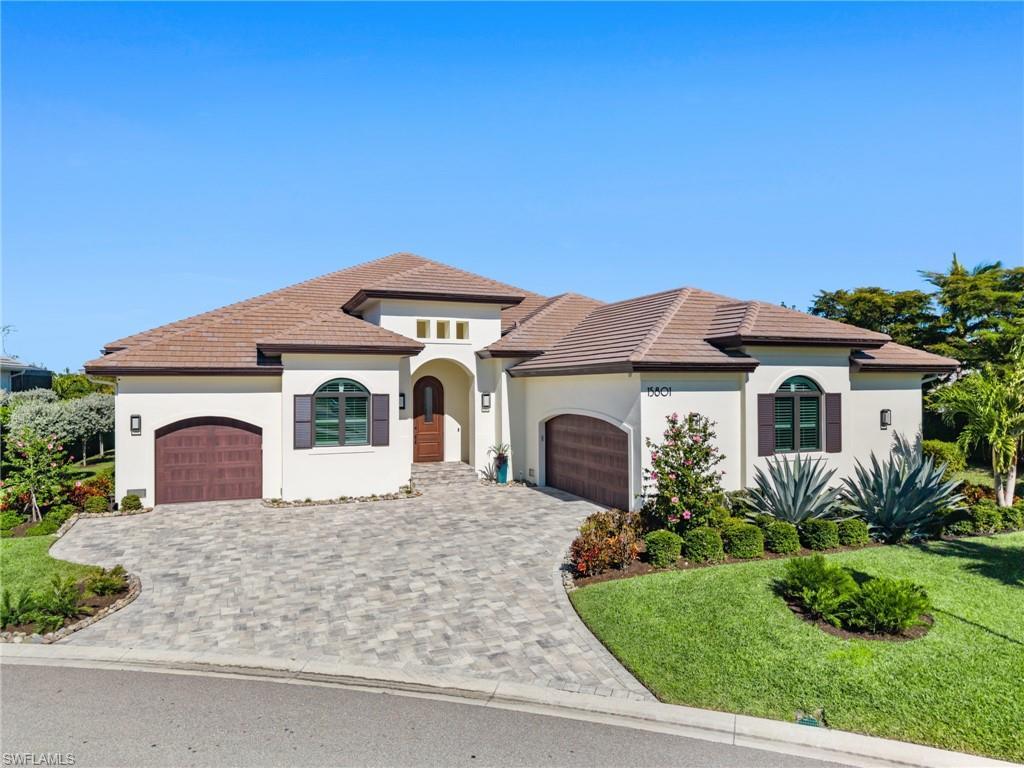 Image 1: Mediterranean / spanish house featuring an attached garage, decorative driveway, a front yard, and stucco siding