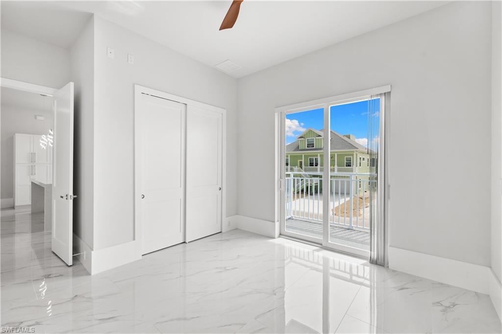 Image 4: Unfurnished bedroom featuring light marble finish floors, a closet, access to exterior, and a ceiling fan