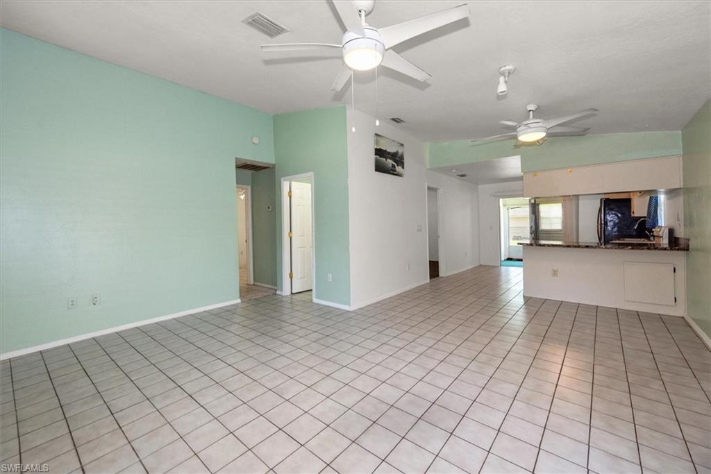 Image 4: Unfurnished living room featuring light tile patterned floors, a ceiling fan, and vaulted ceiling
