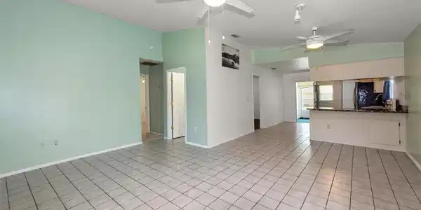 Image 4: Unfurnished living room featuring light tile patterned floors, a ceiling fan, and vaulted ceiling