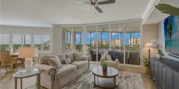 Image 2: Living room with ornamental molding, light wood finished floors, ceiling fan, and floor to ceiling windows
