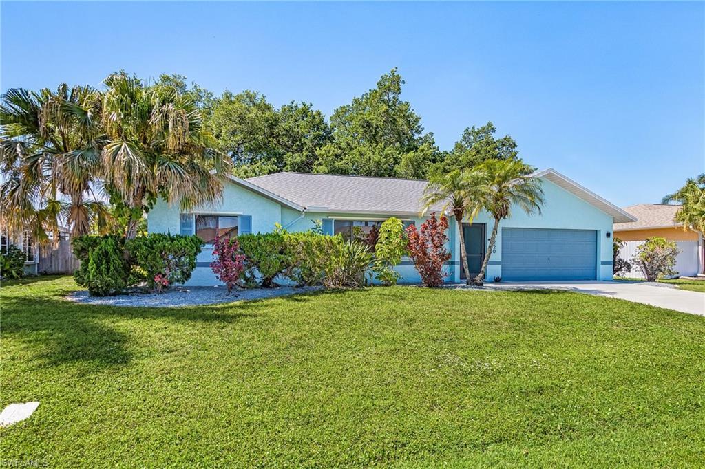 Image 2: Single-story residence featuring a light blue exterior, attached two-car garage, and a manicured lawn