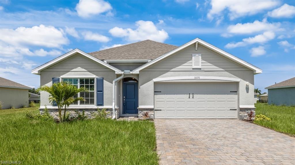 Image 1: Model home. View of front of home with a garage, driveway, a front lawn, and roof with shingles