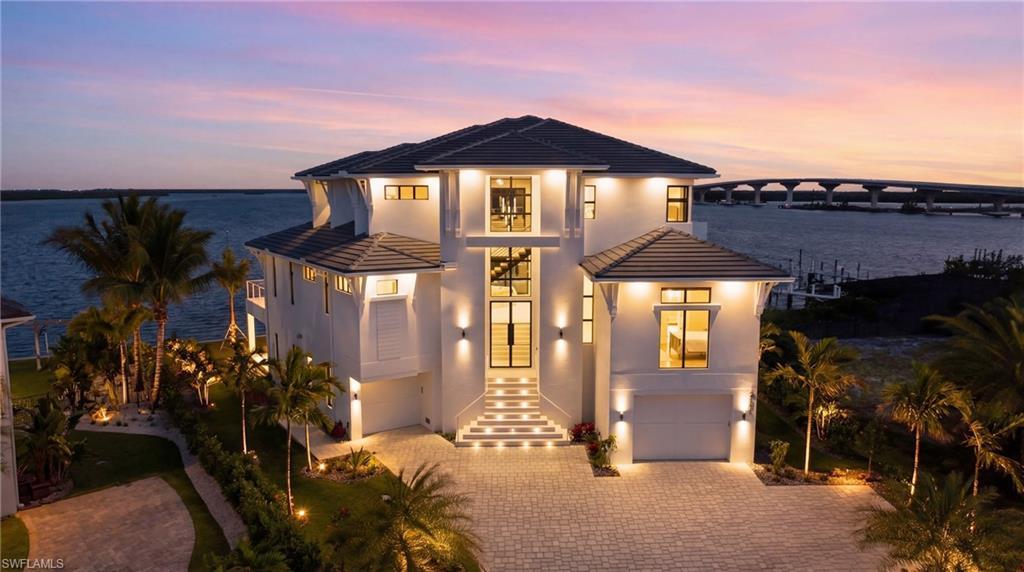 Image 2: Modern home featuring an attached garage, a tile roof, driveway, and stucco siding - Virtually Edited Image