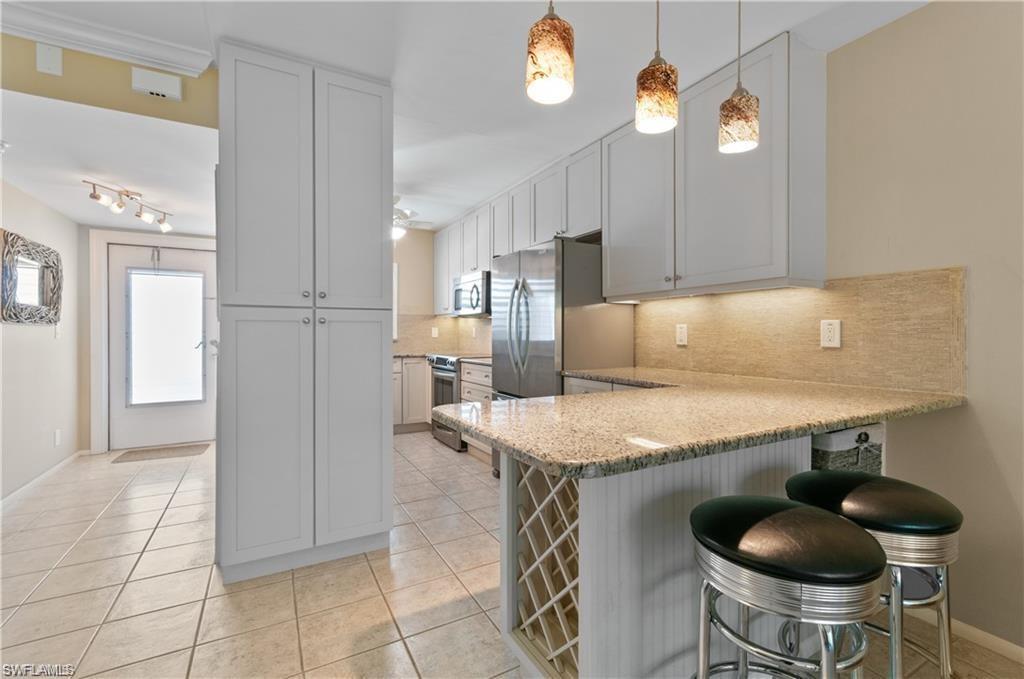 Image 3: Open and spacious Kitchen Bar with granite countertops, under counter storage and stools