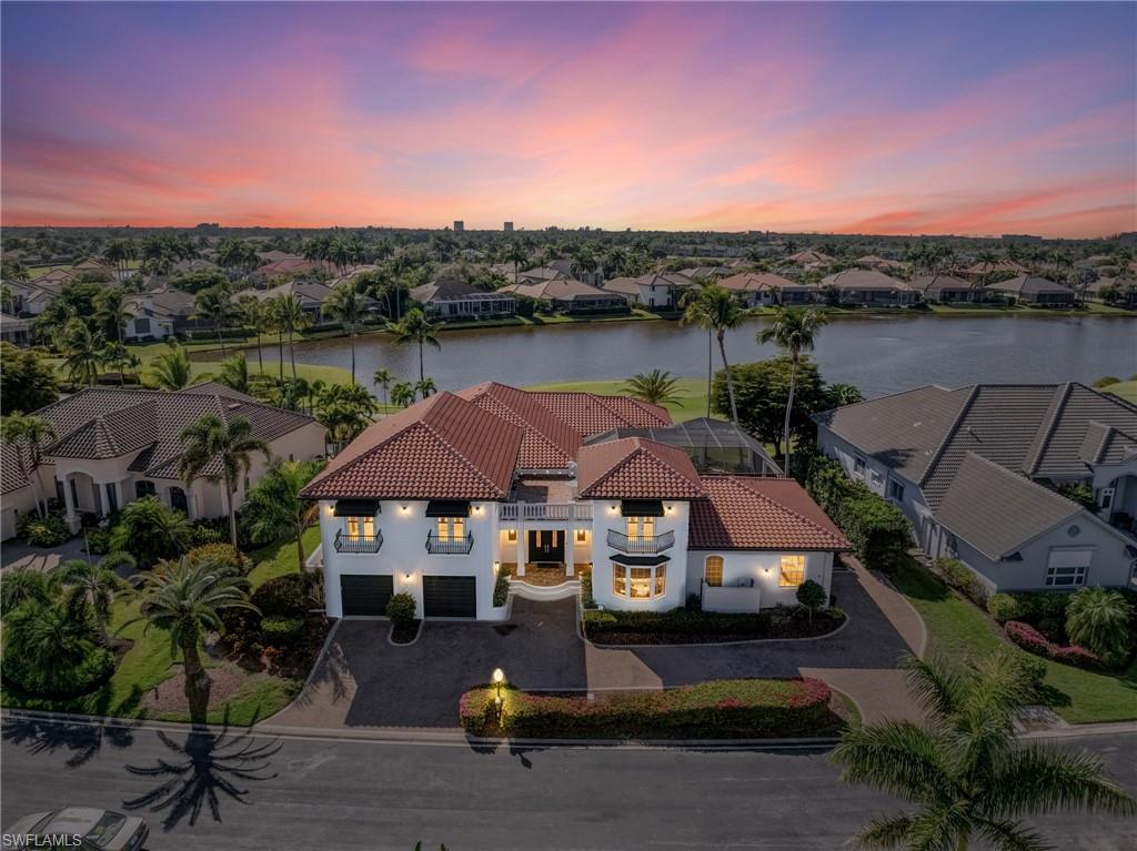 Image 1: Stunning aerial views of this custom architectural masterpiece showcase the home&rsquo;s commanding presence overlooking the 2nd tee box, fairway and the shimmering lake.