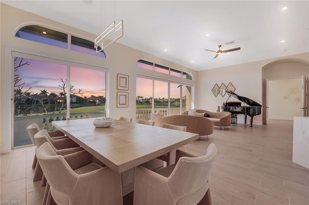 Image 2: Experience awe-inspiring views from the main living area, where endless Florida sunsets, the 2nd tee box, lush fairways, and the expansive lake create a picture-perfect backdrop.