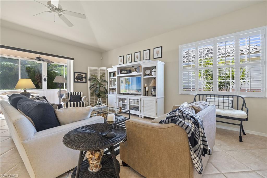 Image 2: Living room featuring ceiling fan, light tile patterned floors, and vaulted ceiling