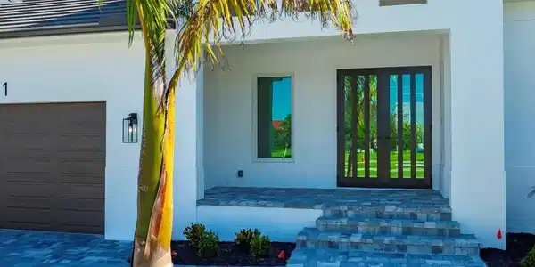 Image 2: Doorway to property featuring stucco siding, an attached garage, driveway, and french doors